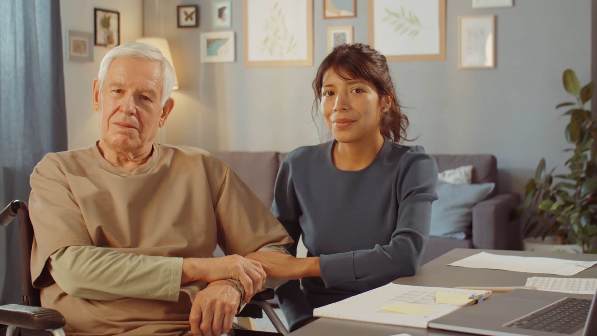 A man in wheelchair with a woman who takes care of him