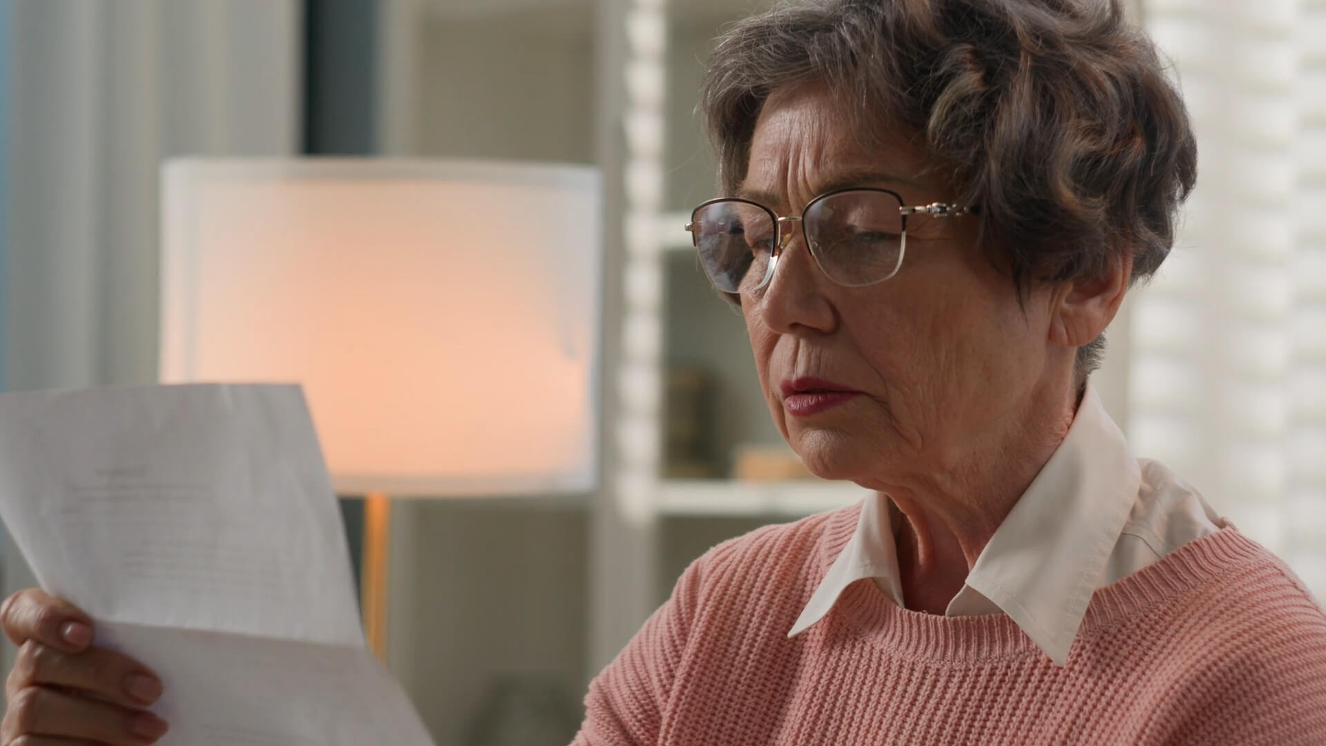 An elderly woman holding papers with her income details