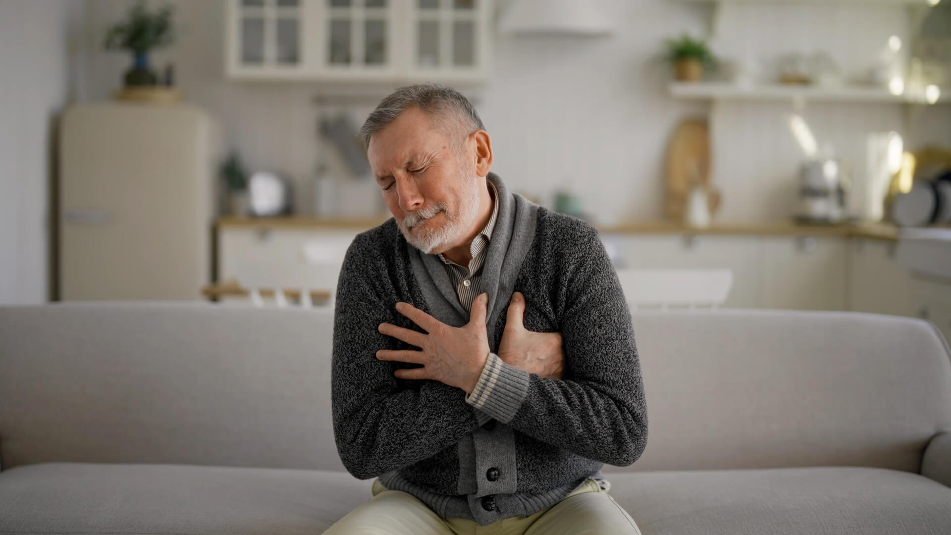 A man clutching his chest due to difficulty breathing and weakness