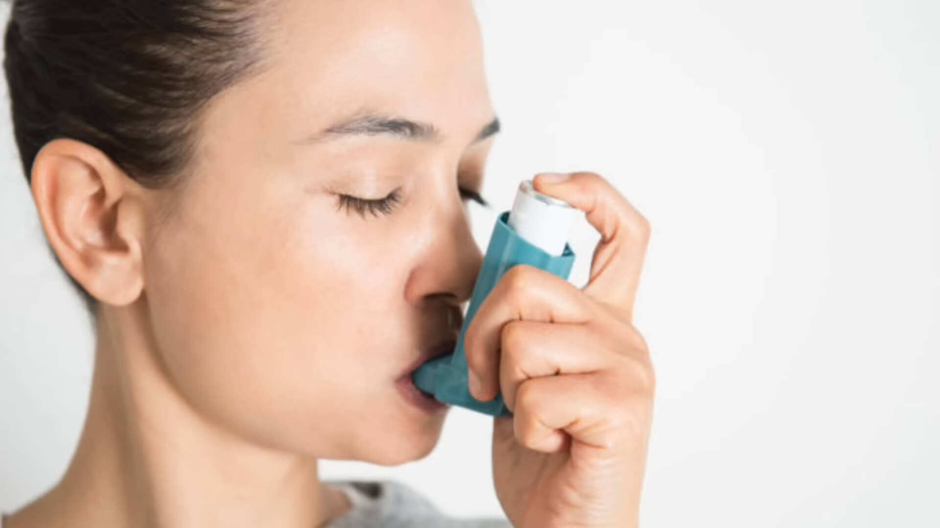 A girl using an inhaler