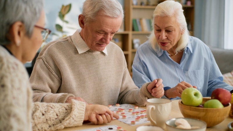 Seniors work together on a trivia game and discuss answers at a table