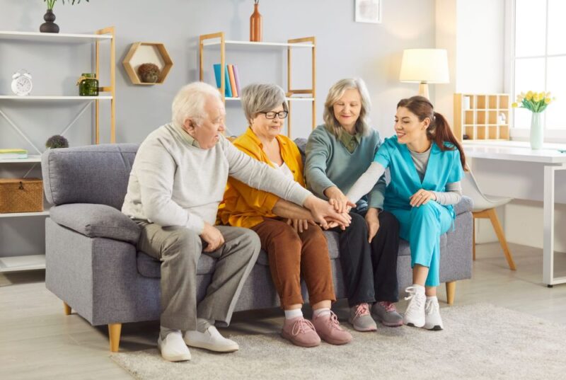 Senior group activity fun with young caring kind nurse, geriatric medicine caretaker helping, nursing home residents, senior adult, assisted living, female doctor visiting patient, caregiving service